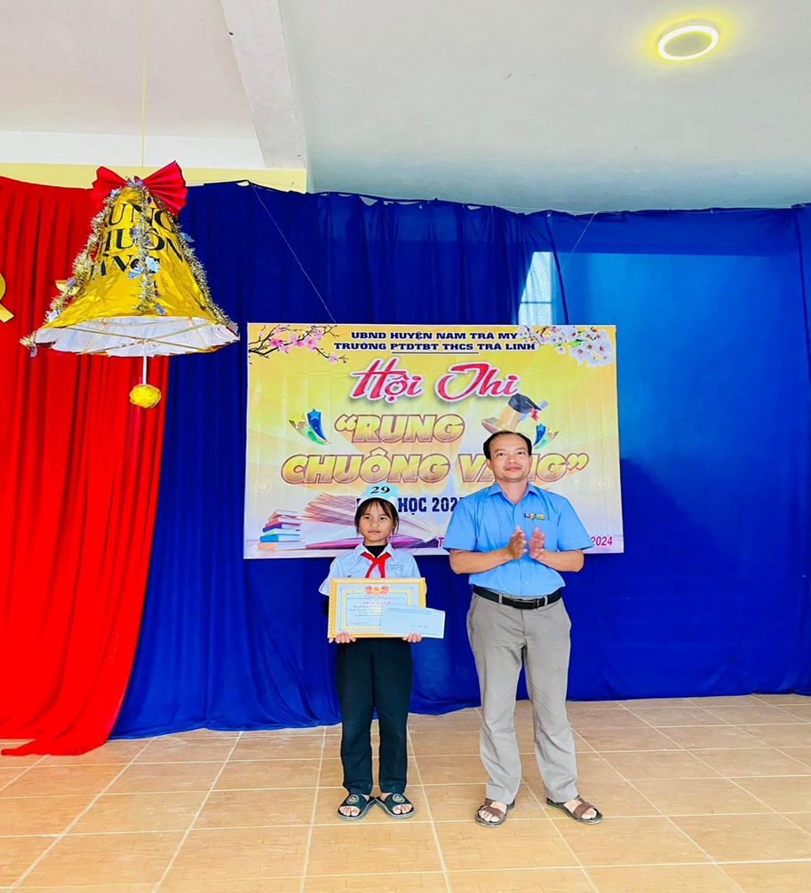 Thầy Nguyễn Đinh Thắng trao giải nhất hội Thi cho em Hồ Thị Tiết học sinh lớp 6/1